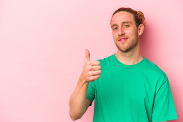 Fototapeta premium Young caucasian man isolated on pink background smiling and raising thumb up