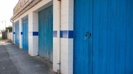 Obraz na płótnie Canvas Puertas de garage en diferentes tono de azul en calle