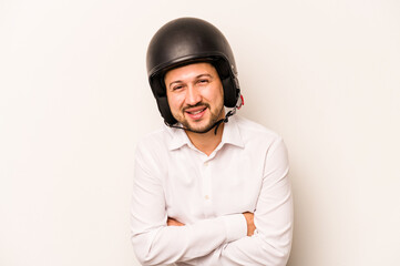Hispanic business man going to work with motorcycle isolated on white background laughing and having fun.