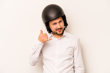 Hispanic business man going to work with motorcycle isolated on white background showing a mobile phone call gesture with fingers.