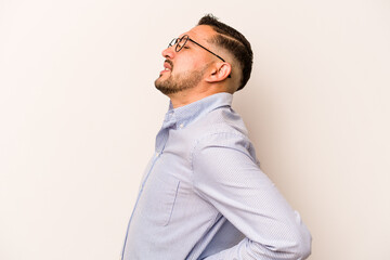 Young hispanic man isolated on white background suffering a back pain.