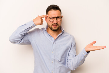 Naklejka premium Young hispanic man isolated on white background holding and showing a product on hand.