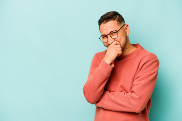 Fototapeta premium Young hispanic man isolated on blue background laughing happy, carefree, natural emotion.