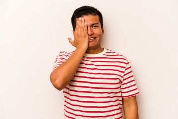 Young hispanic man isolated on white background having fun covering half of face with palm.
