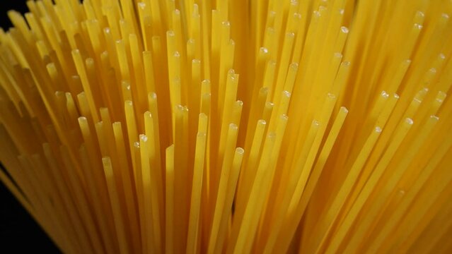 Light sliding on spaghetti on black background. 4k footage