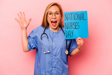 Young nurse woman holding nurse international day isolated on pink background receiving a pleasant...