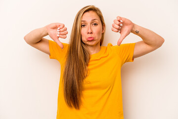 Young caucasian woman isolated on white background showing a dislike gesture, thumbs down....