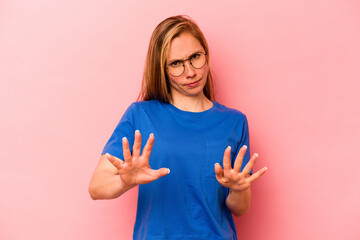 Young caucasian woman isolated on pink background rejecting someone showing a gesture of disgust.