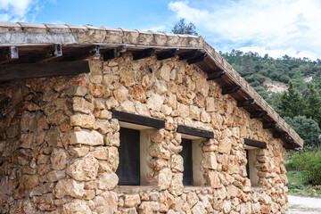 Heavy stone hut on a sunny mountain day.