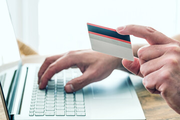 person using credit card and laptop computer for online shopping and payment, e-commerce concept