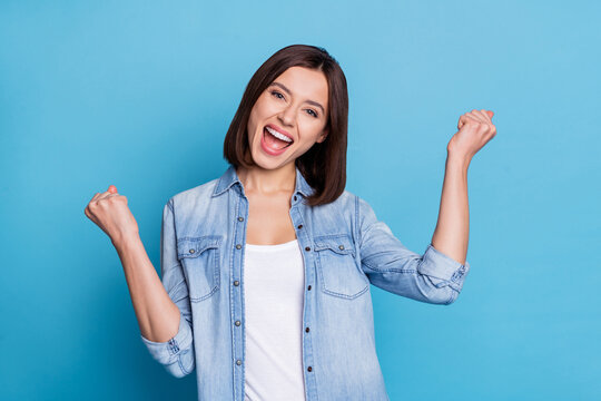 Portrait of overjoyed glad person raise fists celebrate achievement luck isolated on blue color background