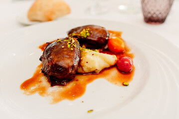 Iberian cheek served on an elegant plate in a restaurant, fat, caloric and protein food.