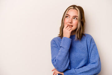 Young caucasian woman isolated on white background relaxed thinking about something looking at a copy space.