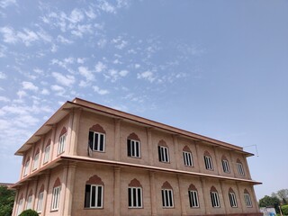 Picture of entrance gate of Govind devji temple with white clouds in blue sky shot in the morning from a wide angle lens