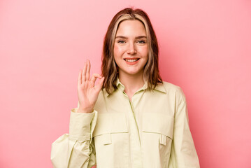 Young caucasian woman isolated on pink background cheerful and confident showing ok gesture.