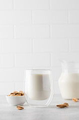 Organic almond milk in a glass on a light background. Alternative to dairy products. Copy space