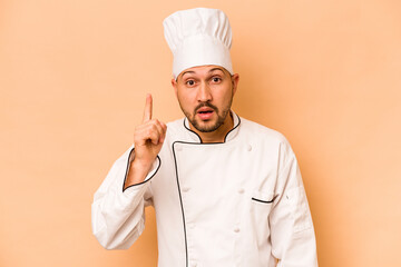 Hispanic chef man isolated on beige background having an idea, inspiration concept.