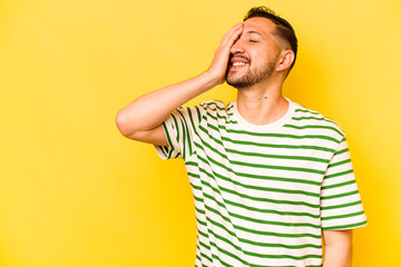 Young hispanic man isolated on yellow background laughing happy, carefree, natural emotion.