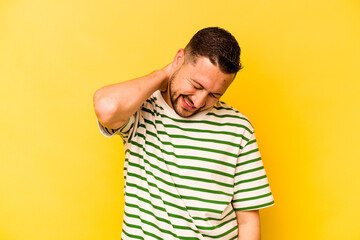 Young hispanic man isolated on yellow background suffering neck pain due to sedentary lifestyle.