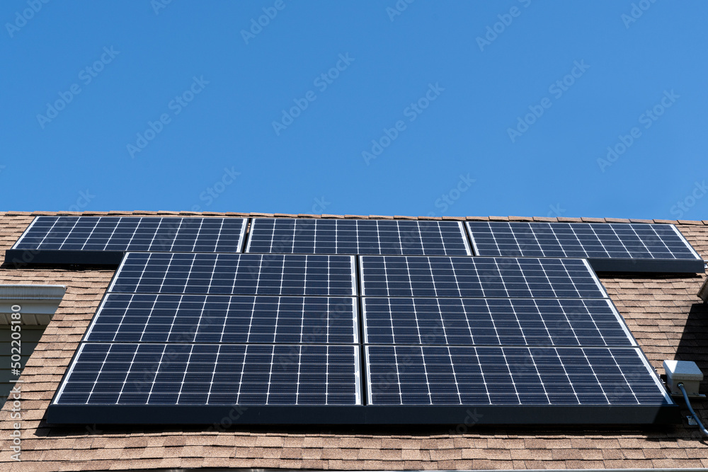 Wall mural a residential solar panel array mounted on an asphalt shingle roof with copy space