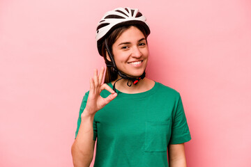 Young caucasian woman wearing helmet isolated on pink background cheerful and confident showing ok gesture.