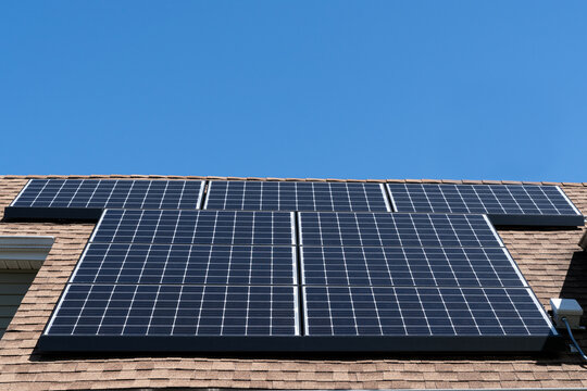 A Residential Solar Panel Array Mounted On An Asphalt Shingle Roof With Copy Space