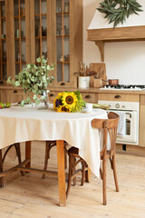 Interior design scandinavian kitchen with round table and chairs. Stylish dining room with wooden retro furniture. Cozy cuisine  decorated with summer decor. Kitchen utensils, dishes, plates. 
