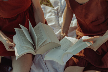 Obraz premium Happy multi-ethnic girls studying outside in the countryside. 