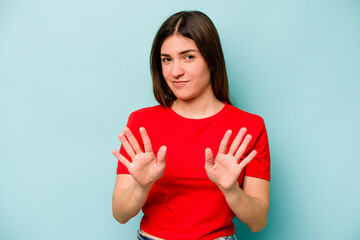 Young caucasian woman isolated on blue background rejecting someone showing a gesture of disgust.