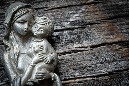 Virgin Mary with the baby Jesus Christ against wooden background. Religion, faith, eternal life, God, the soul concept. Copy space.