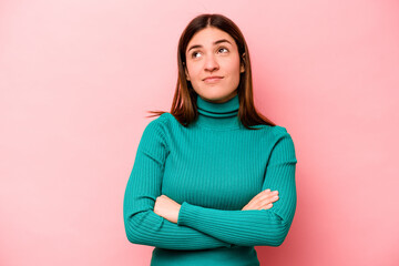 Young caucasian woman isolated on pink background dreaming of achieving goals and purposes