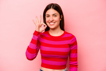 Young caucasian woman isolated on pink background cheerful and confident showing ok gesture.