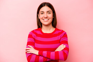 Fototapeta premium Young caucasian woman isolated on pink background who feels confident, crossing arms with determination.