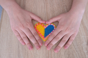 close-up of heart, children's hands creating perler bead patterns, make flag of ukraine using thermomosaic technique, perler bead art, development of fine motor skills, thermo mosaic ideas