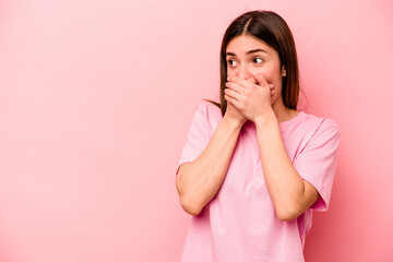 Young caucasian woman isolated on pink background thoughtful looking to a copy space covering mouth with hand.