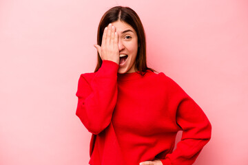 Young caucasian woman isolated on pink background having fun covering half of face with palm.