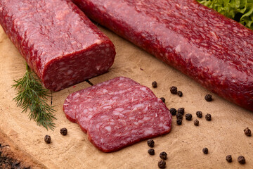 Salami smoked sausage with green peppercornson wooden cutting board.Selective focus