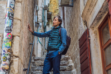 Man tourist enjoying Colorful street in Old town of Kotor on a sunny day, Montenegro. Travel to Montenegro concept