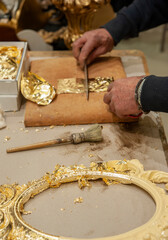 Application of gold leaf to a frame. Gilding process technique..