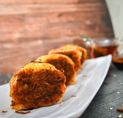 Indonesian snack, Roti gulung abon ikan tuna or Shredded tuna roll on a white folding plate.