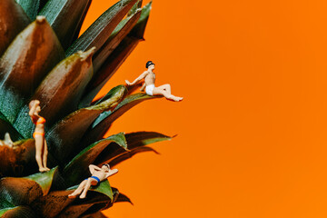 miniature people on the leaves of a pineapple