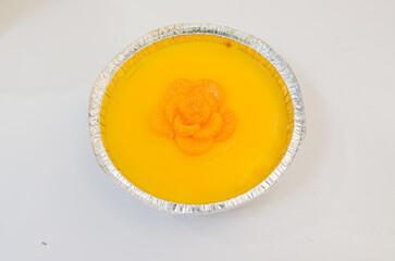 Orange cake decorated with fresh oranges placed on a white background.