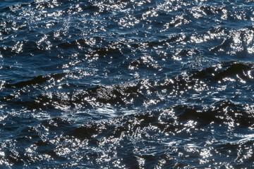 sunshine on dark blue waves of river
