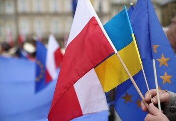 flags of countries Poland, Ukraine and European Union in person hand during street demonstration - obrazy, fototapety, plakaty