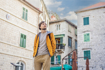 Obraz na płótnie Canvas Man tourist enjoying Colorful street in Old town of Kotor on a sunny day, Montenegro. Travel to Montenegro concept