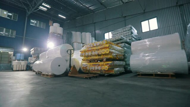 Large modern warehouse in the factory. Large warehouse in a nonwovens factory. Industrial interior. Lots of big rolls of spunbond. Warehouse with rolls of nonwovens.
