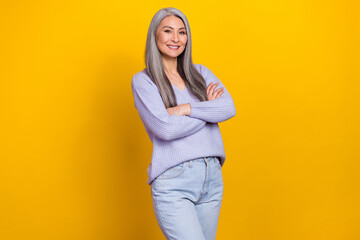 Obraz premium Photo of charming mature skilled business lady with folded arms own modern company isolated on yellow color background