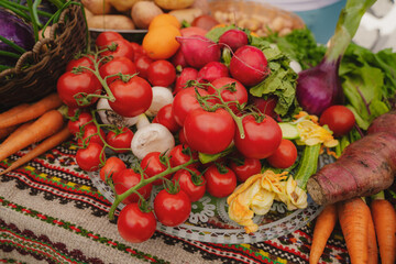 Fresh vegetables on the table. Carrot, garlic, tomato, zucchini flowers, beetroot, kohlrabi, onion, marrow, potatoes, celery, radish, cucumber,  peas. Healthy organic food concept. 