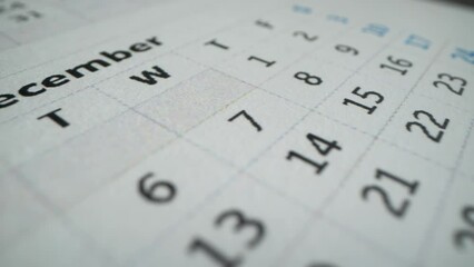 December page of 2022 wall calendar followed by the January page of a new 2023 calendar. Calendar of this year. Macro shot of many dates, business days and holidays. Cristmas time