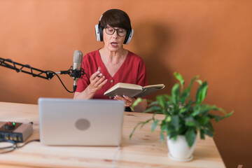 Middle-aged woman radio host making podcast recording for online show - broadcast and dj concept
